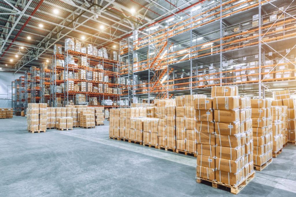 Large industrial warehouse with high racks and cardboard boxes for assessment