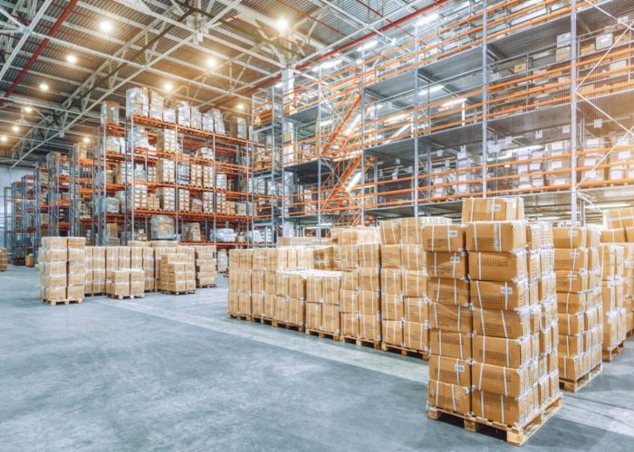 Large industrial warehouse with high racks and cardboard boxes for assessment